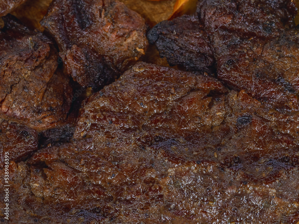 Detail of a well cooked grilled steak with marked lines and juicy Detail of a well cooked grilled steak with marked lines and juicy