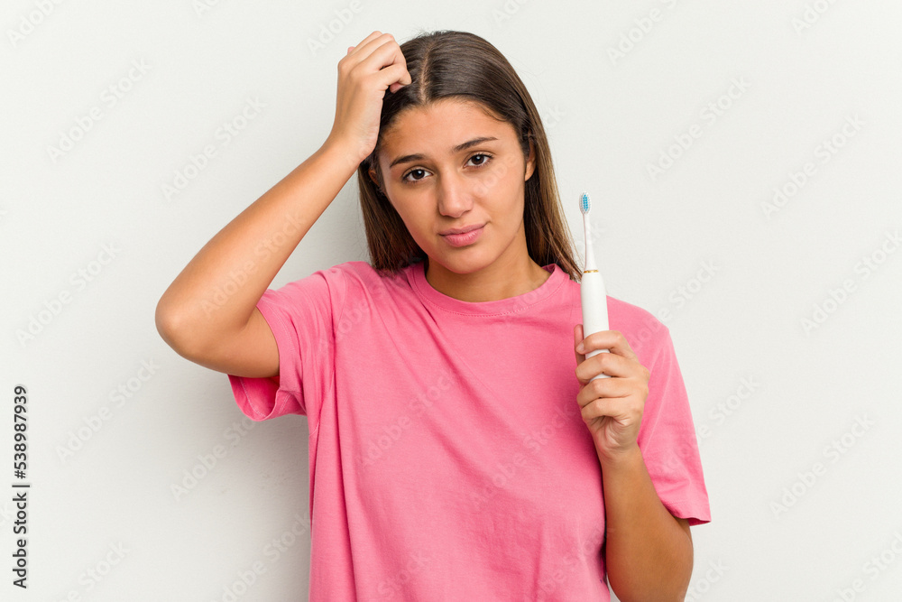 Young Indian woman brushing teeth isolated on white background being shocked, she has remembered important meeting. Young Indian woman brushing teeth isolated on white background being shocked, she has remembered important meeting.