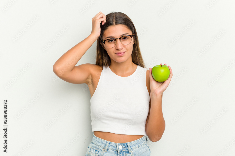 Young Indian woman holding an apple isolated on white background being shocked, she has remembered important meeting. Young Indian woman holding an apple isolated on white background being shocked, she has remembered important meeting.