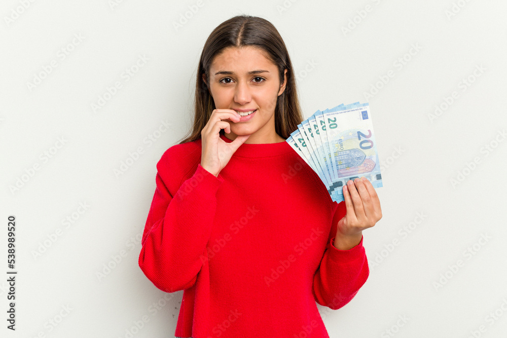 Young Indian woman holding a banknotes isolated on white background biting fingernails, nervous and very anxious. Young Indian woman holding a banknotes isolated on white background biting fingernails, nervous and very anxious.