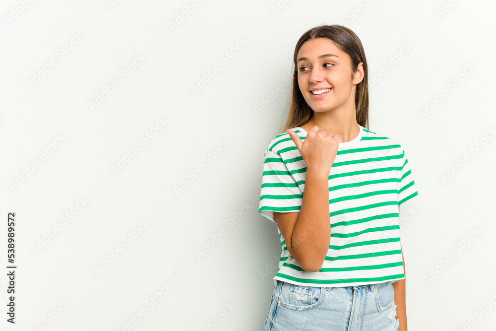 Young Indian woman isolated on white background points with thumb finger away, laughing and carefree. Young Indian woman isolated on white background points with thumb finger away, laughing and carefree.