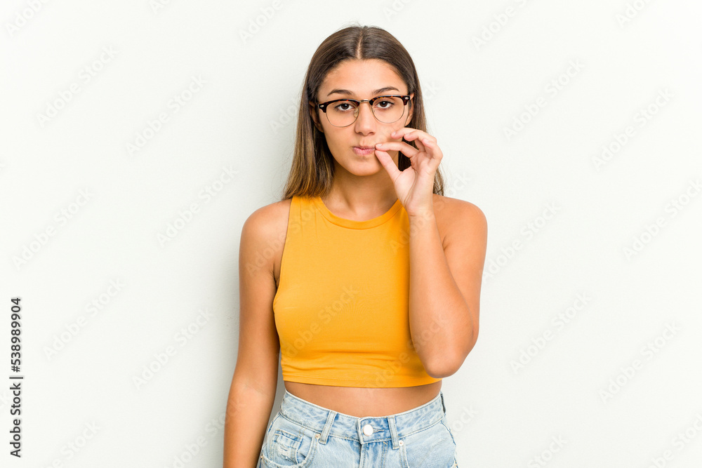 Young Indian woman isolated on white background with fingers on lips keeping a secret. Young Indian woman isolated on white background with fingers on lips keeping a secret.