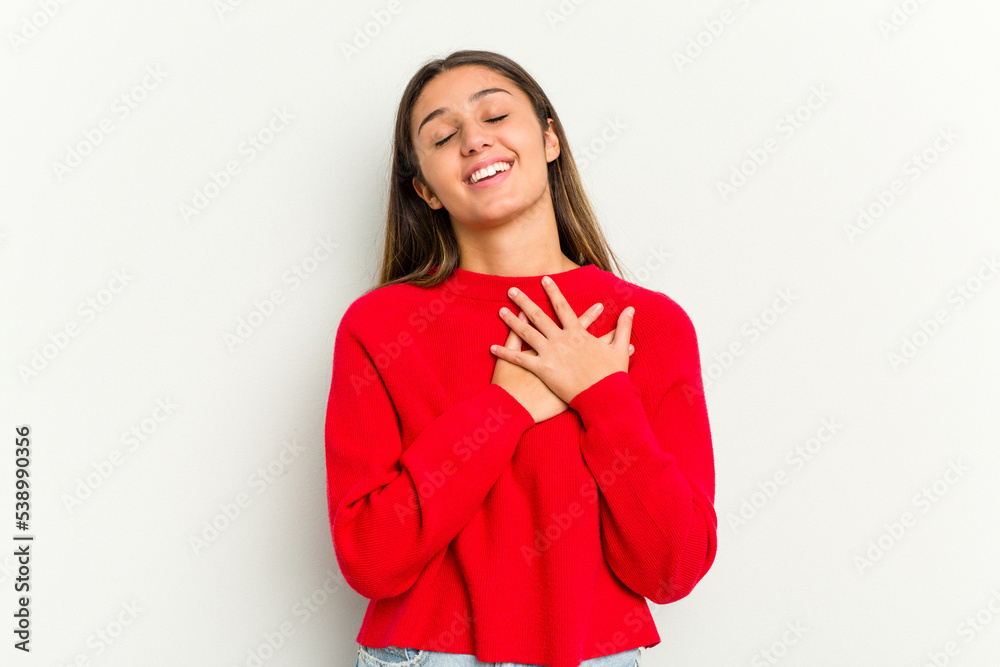 Young Indian woman isolated on white background has friendly expression, pressing palm to chest. Love concept.