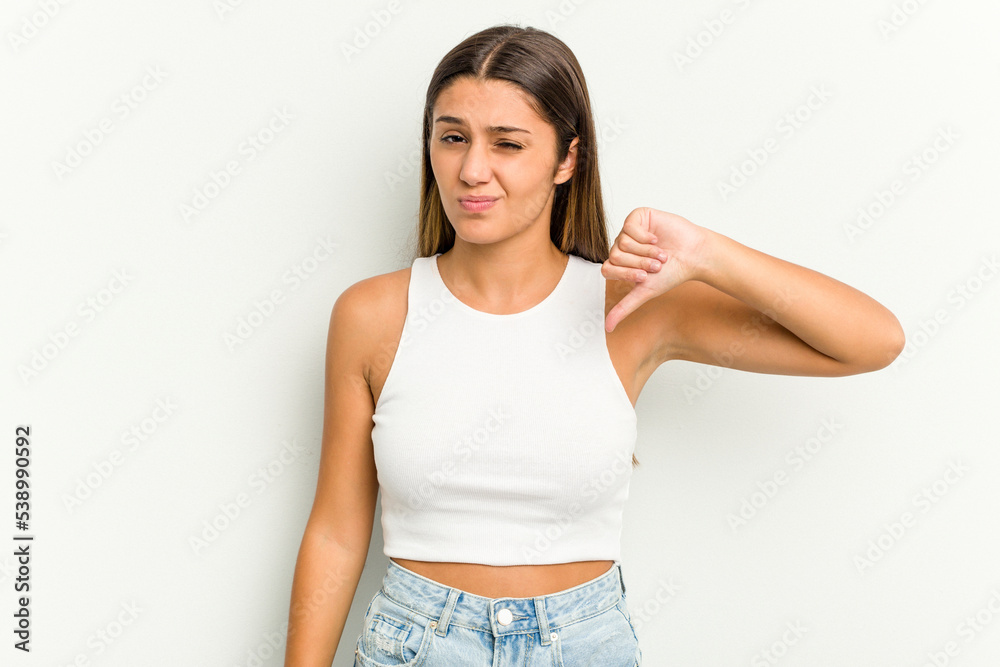 Young Indian woman isolated on white background showing thumb down, disappointment concept. Young Indian woman isolated on white background showing thumb down, disappointment concept.
