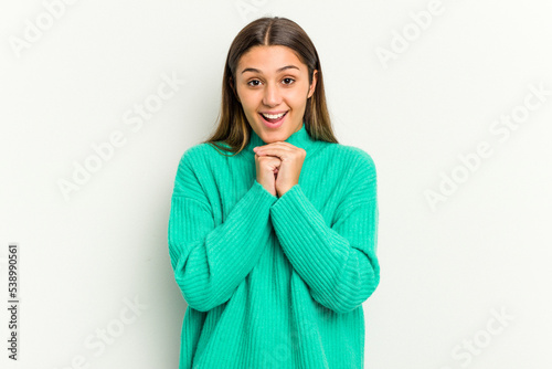 Young Indian woman isolated on white background praying for luck, amazed and opening mouth looking to front.
