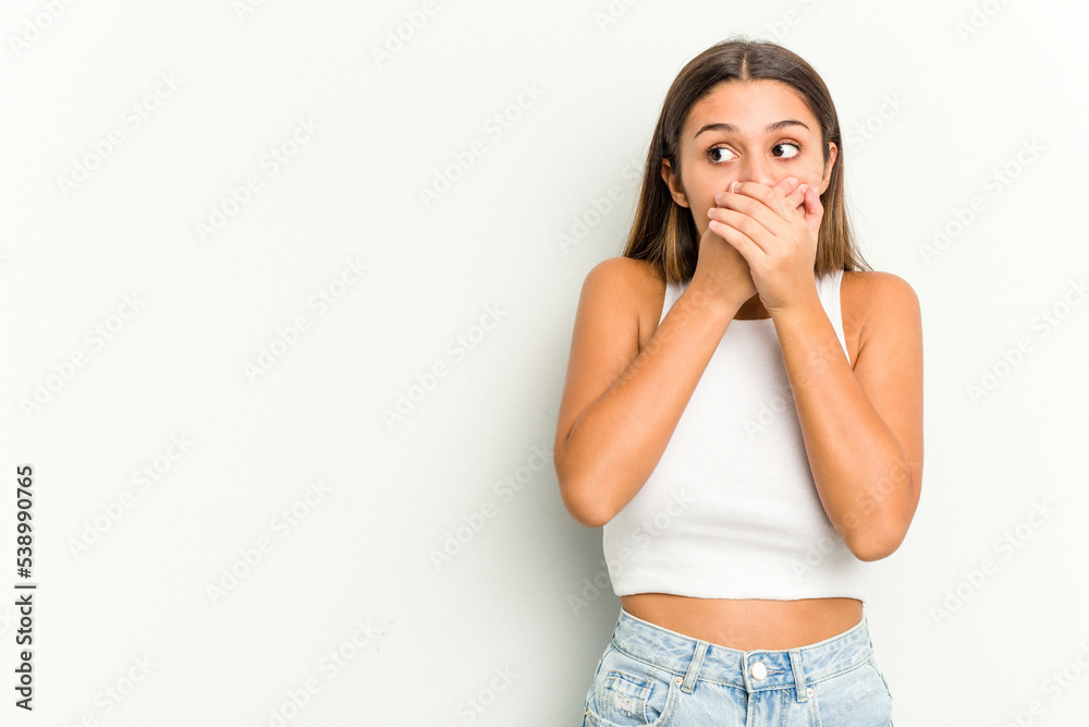 Young Indian woman isolated on white background thoughtful looking to a copy space covering mouth with hand. Young Indian woman isolated on white background thoughtful looking to a copy space covering mouth with hand.