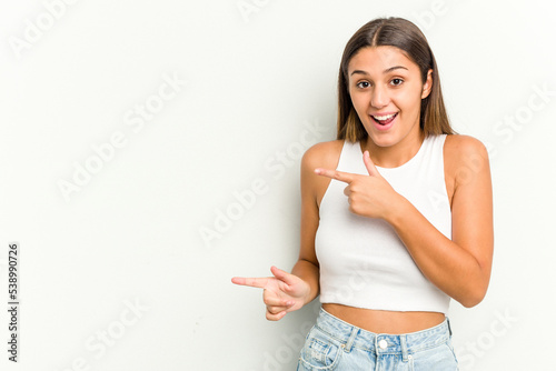 Young Indian woman isolated on white background excited pointing with forefingers away.