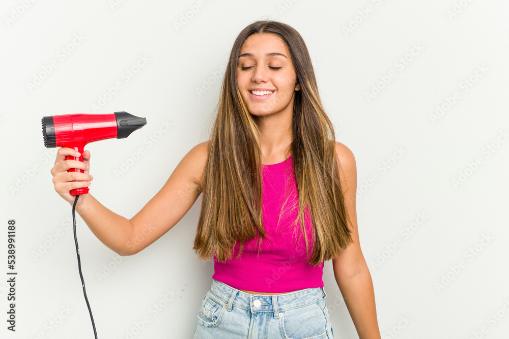 Young Indian woman holding a hairdryer isolated on white background Young Indian woman holding a hairdryer isolated on white background