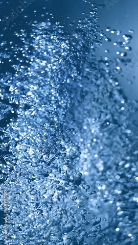 Effervescent fizz and clean hygiene, rejuvenate cosmetics or renewable energy. Studio shot of transparent cosmetic blue gas bubbles under water in full-frame macro close up with selective focus blur.