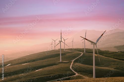 A wind farm or wind park at sunset located in the mountains of Italy Europe and it allows to realize clean energy. It’s sustainable, renewable energy for enviromental