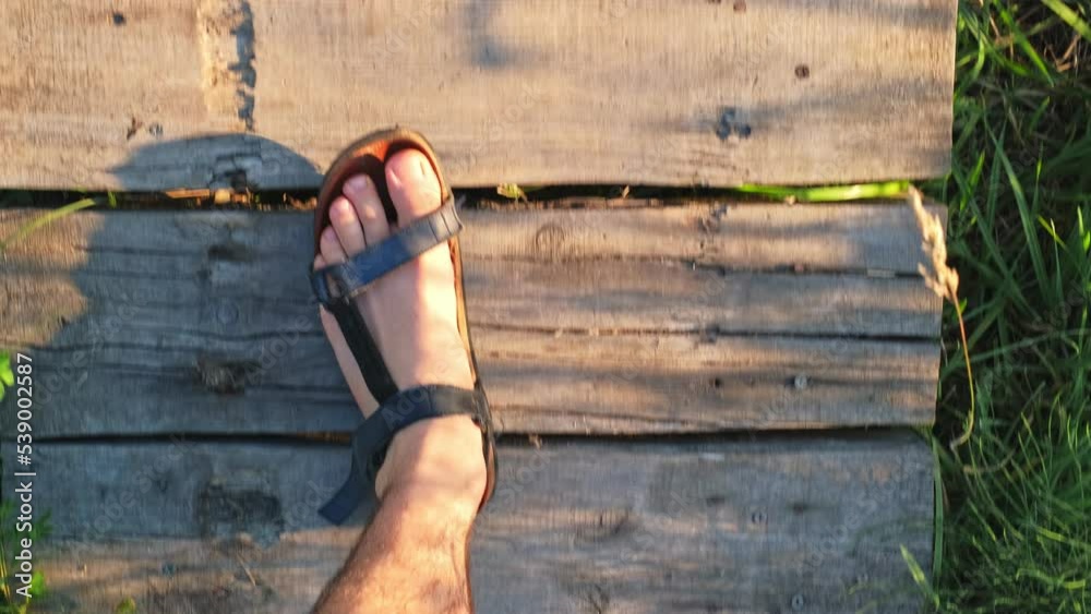 Caucasian Man Wearing Sport Leather Sandals Walking over Wooden Bridge Caucasian Man Wearing Sport Leather Sandals Walking over Wooden Bridge