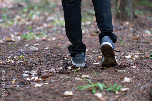 close up feet of person walking in the forest, trail hiking