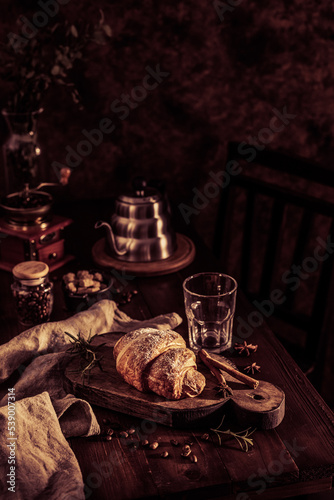 Homemade croissant and cup of coffee kettle at wood table and relax time break concept. Coffee set