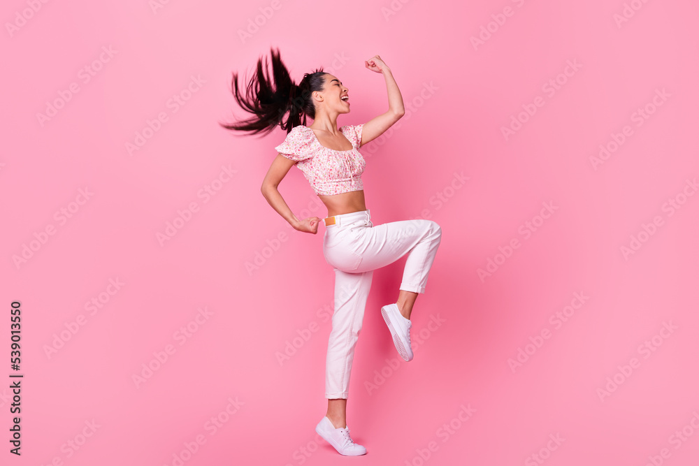 Full body profile portrait of astonished positive lady raise fists accomplishment isolated on pink color background Full body profile portrait of astonished positive lady raise fists accomplishment isolated on pink color background