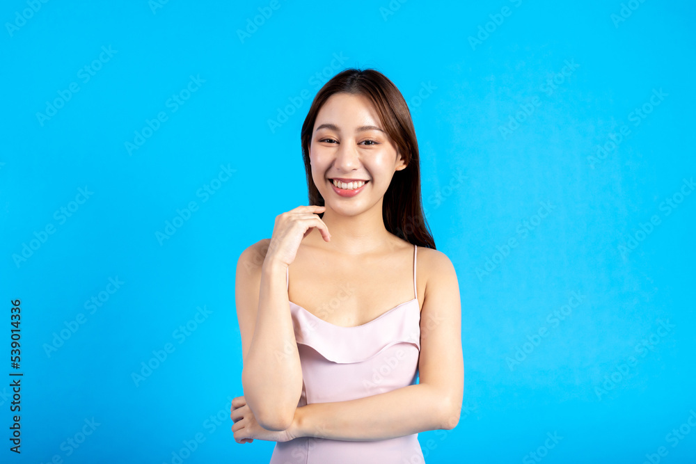 Happy smiling Asian female stylish woman looking at camera and posing isolated in blue background. Charming 20s girl crossed arms showing confidence in half body length studio shot - copy space Happy smiling Asian female stylish woman looking at camera and posing isolated in blue background. Charming 20s girl crossed arms showing confidence in half body length studio shot - copy space