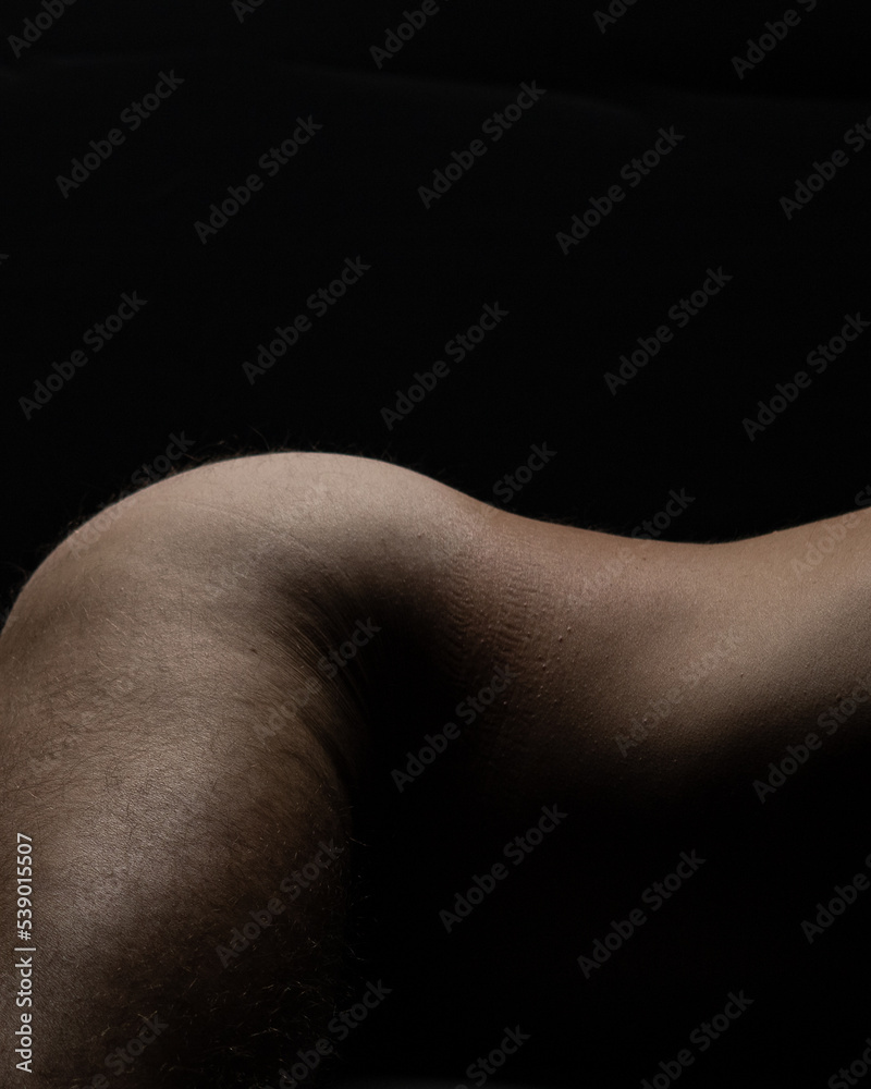Naklejka premium closeup nude athletic male hips and back, naked Caucasian man fitness model photo isolated on black background vertical skin tones