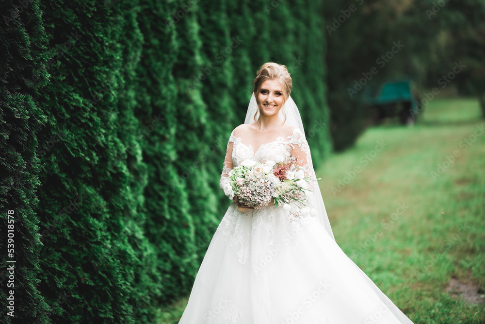 Luxury wedding bride, girl posing and smiling with bouquet Luxury wedding bride, girl posing and smiling with bouquet
