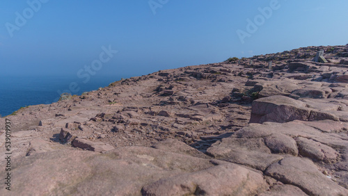 Detail of red rock formation with sea in the background at Cap Frehel, Cote d'Amour, Brittany, France