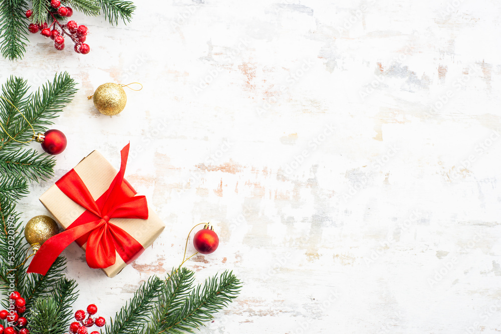 Christmas gift box with fir tree and holiday decorations at white background. Flat lay composition. Christmas gift box with fir tree and holiday decorations at white background. Flat lay composition.