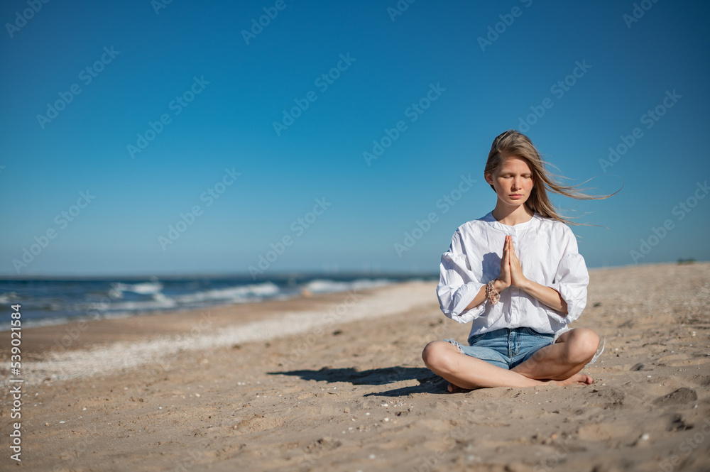 Girl practice meditation on the beach. With space for text or design Girl practice meditation on the beach. With space for text or design