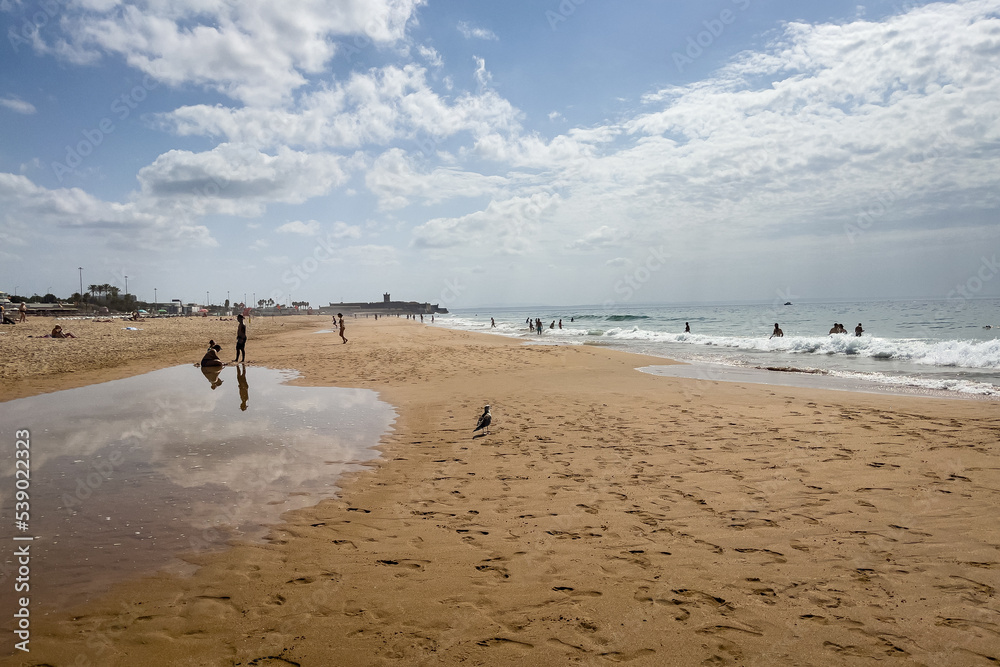 People enjoying their time on the beach in Carcavelos, Portugal