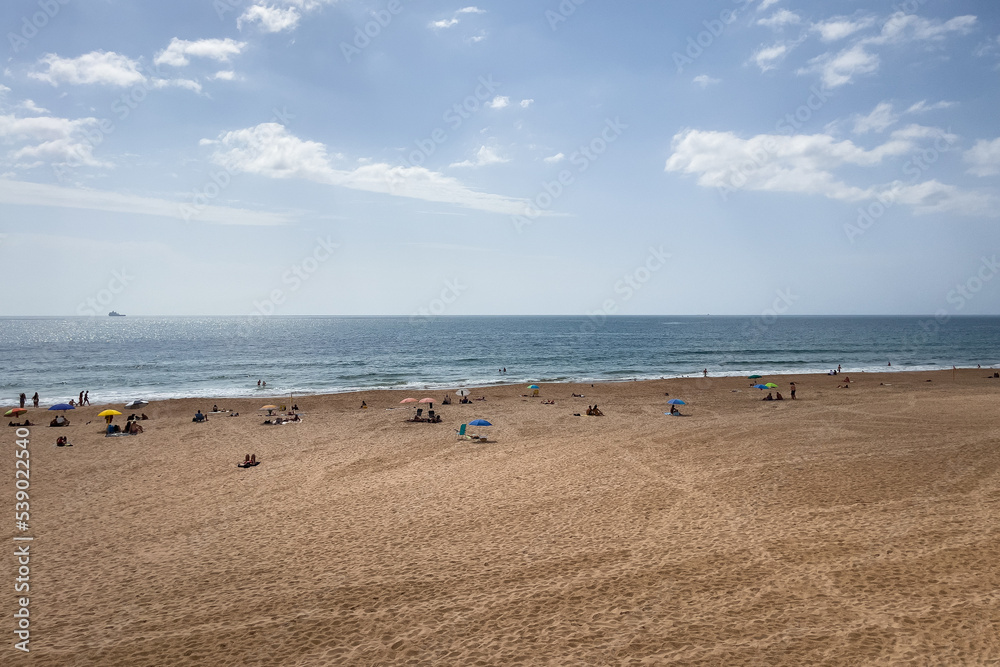 People enjoying their time on the beach in Carcavelos, Portugal