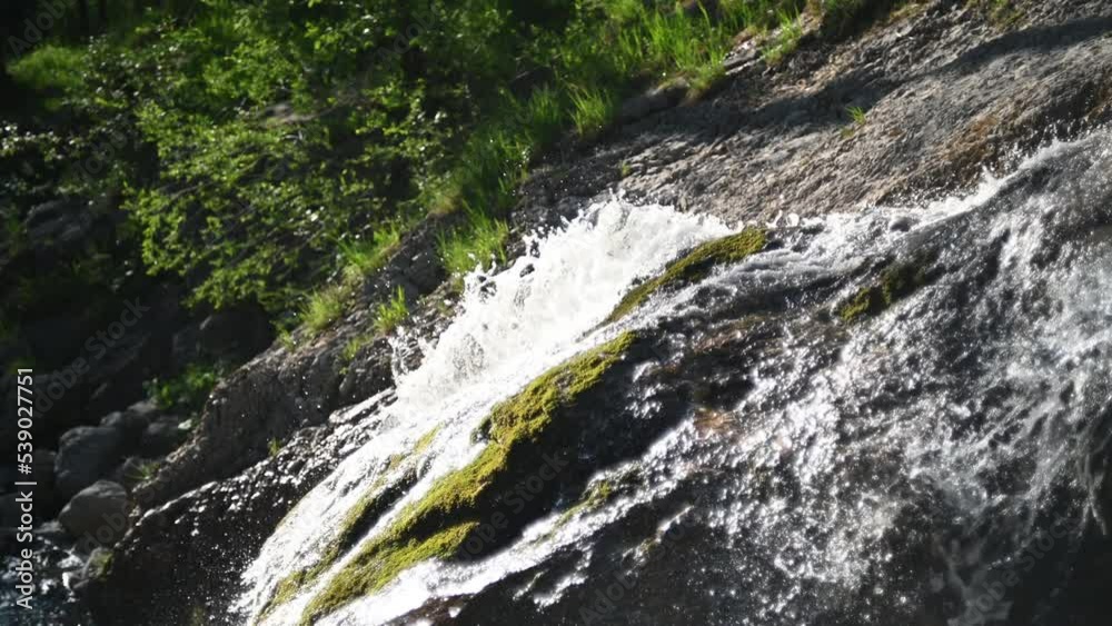 Water runs over mossy rocks in a forest Water runs over mossy rocks in a forest
