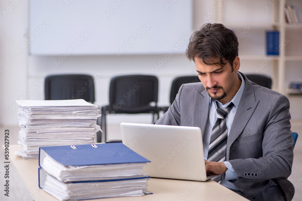 Young businessman employee and too much work in the office Young businessman employee and too much work in the office