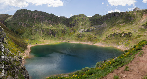 Vistas panorámicas preciosas del lago del Valle en Asturias, con agua turquesa, rodeado de montañas verdes, cielo azul, nube blanca en un entorno natural relajado, verano de 2021 España.