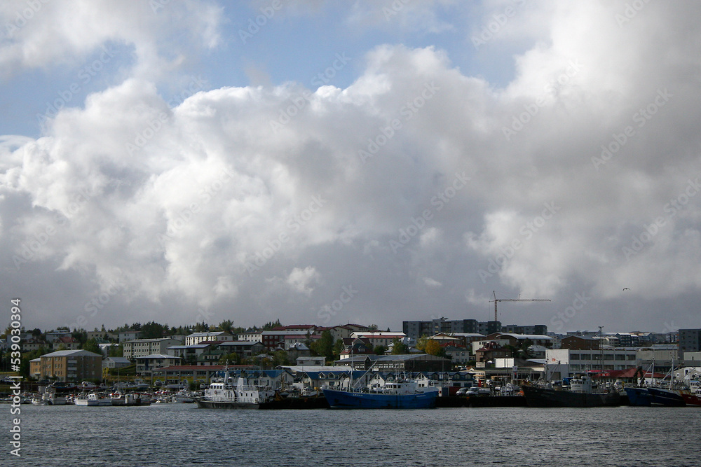 Reykjavik, Iceland - Reykjavik’s coastline with several boats, under a blue sky with clouds. Image has copy space.