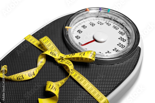 Bathroom scale with a measuring tape on background photo
