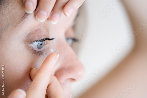 girl putting on contact lenses