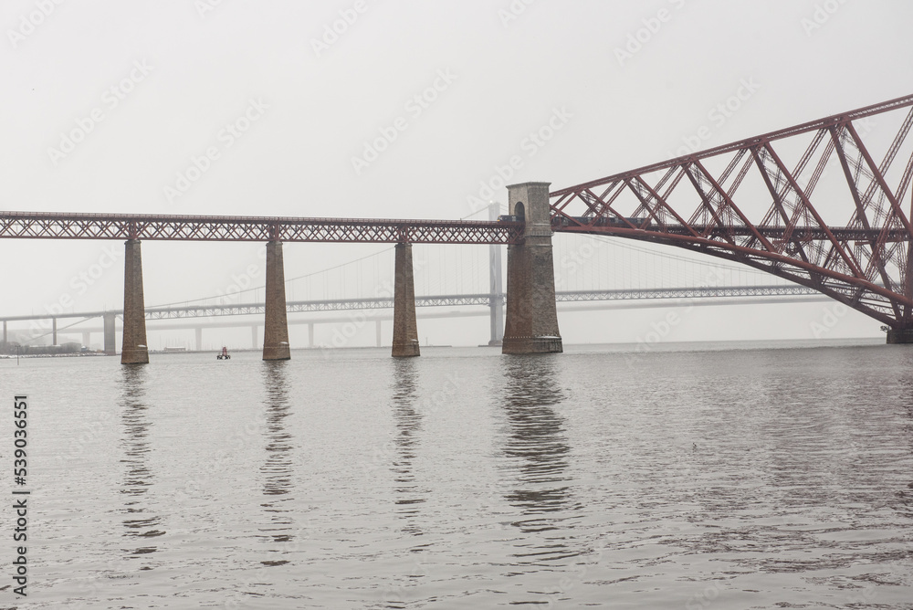 View of the George IV Bridge Rail Bridge across the water of the Firth of Forth in an overcast Winter day in Edinburgh, Scotland, UK, where the Queensferry Crossing and the Firth of Forth Road Bridge 