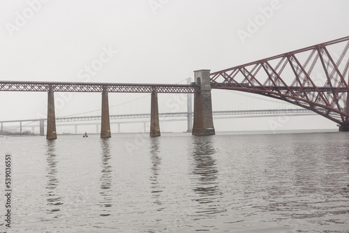 View of the George IV Bridge Rail Bridge across the water of the Firth of Forth in an overcast Winter day in Edinburgh, Scotland, UK, where the Queensferry Crossing and the Firth of Forth Road Bridge 