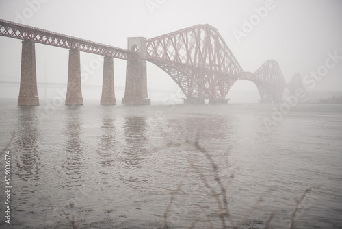 View of the George IV Bridge Rail Bridge from South Queensferry across the water of the Firth of Forth in an Winter day in Edinburgh, Scotland, UK, under low visibility due to the snow during a blizza © CarlosGLopez