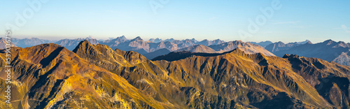 Alpine mountain peaks illuminated by rising sun photo