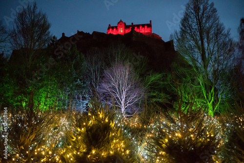 View of Princes Street Gardens with Christmas decorated trees and a colourful light display in Scotland, Uk, with an illuminated Edinburgh Castle on the background during Christmas time photo