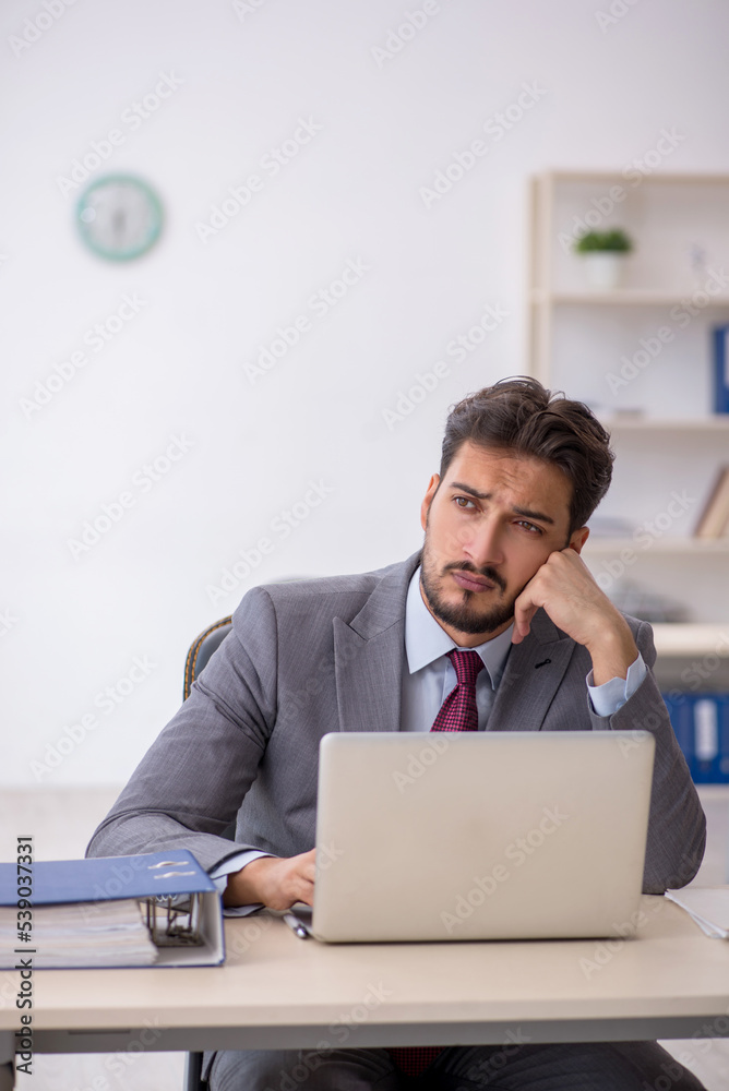 Young male employee working in the office Young male employee working in the office