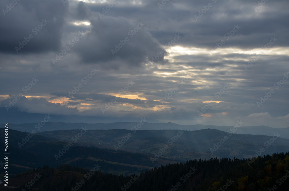Autumn landscape with mountain ridges under low clouds. Carpathian Mountains in Ukraine
