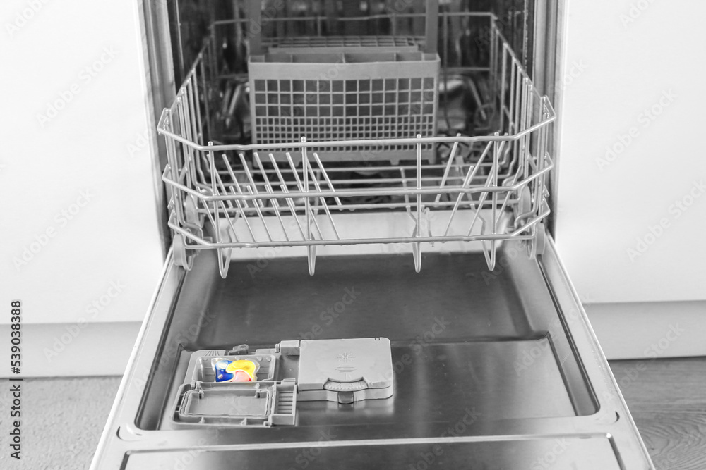 Dishwasher. Loading dishes. Dishwashing capsules. Open dishwasher with clean dishes in the white