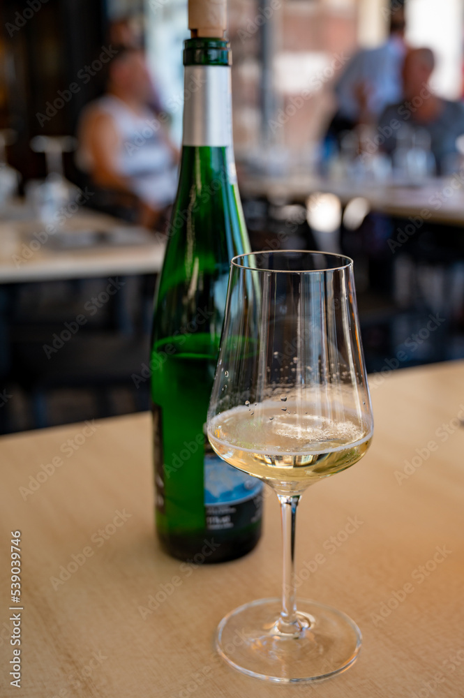 Drinking of txakoli or chacolí slightly sparkling very dry white wine produced in Spanish Basque Country, served in restaurant in Getaria, Spain