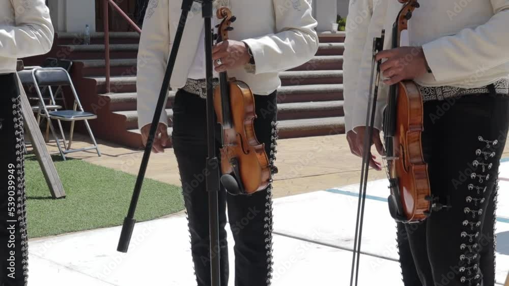 group of mariachi mexican music playing violin and singing in a public mexican fiesta at a park