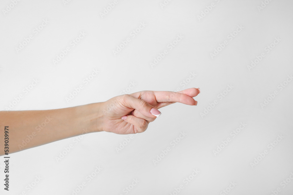 Woman's hand keeps fingers crossed on white background Woman's hand keeps fingers crossed on white background