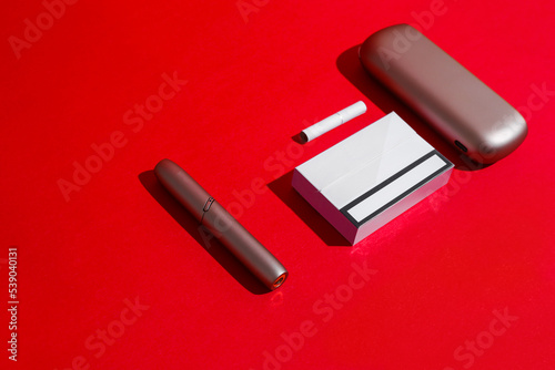 electronic cigarette with sticks on a red background. Smoking concept, woman devices photo