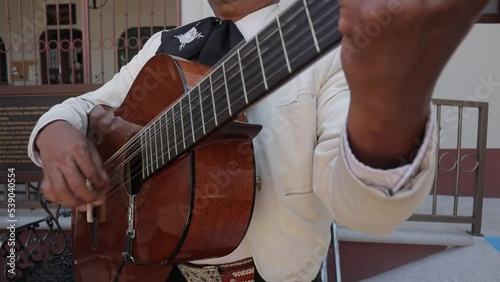group of mariachi mexican music playing guitar in a public mexican fiesta at a park