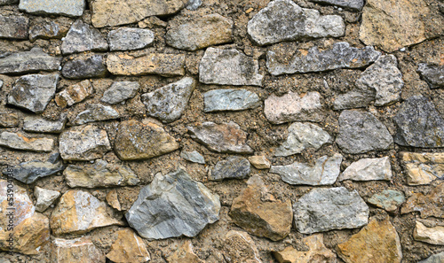 Real wall and stonework to use as background. Close-up of a fragment of an old natural stone wall. Stone background for design development