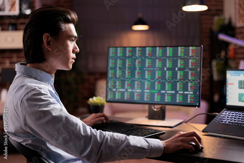 Male worker analyzing stock market trade on computer, working with web 3.0 hypertext on laptop. Looking at real time global investment and capital money profit exchange, doing financial remote job. photo