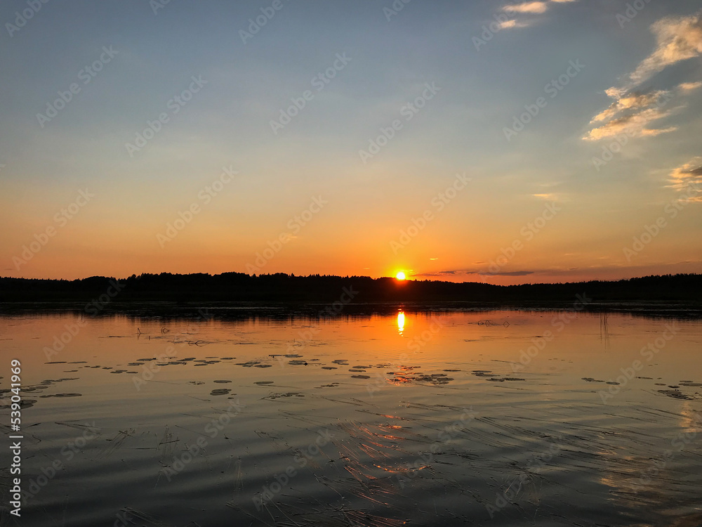 View of the sunset on the lake with water lilies on the water. Tourism, travel and vacation concept.