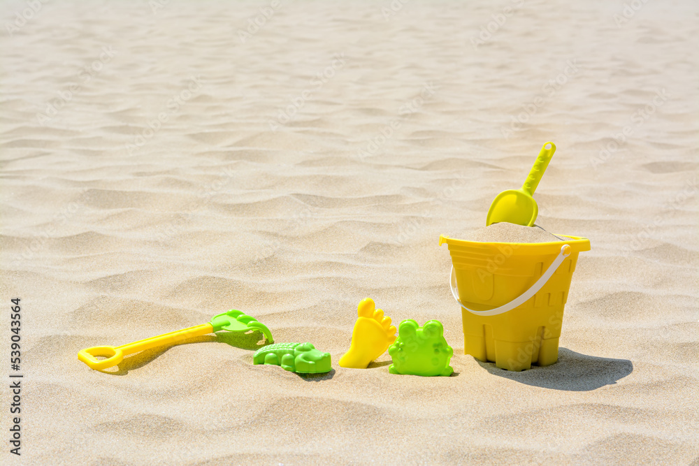Set of colorful beach toys on sand. Space for text Set of colorful beach toys on sand. Space for text