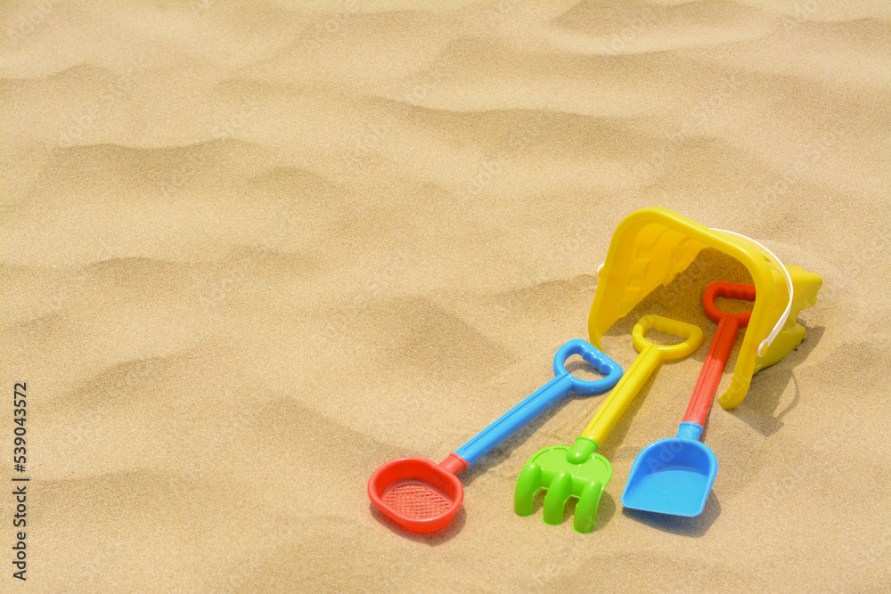 Set of colorful beach toys on sand. Space for text Set of colorful beach toys on sand. Space for text